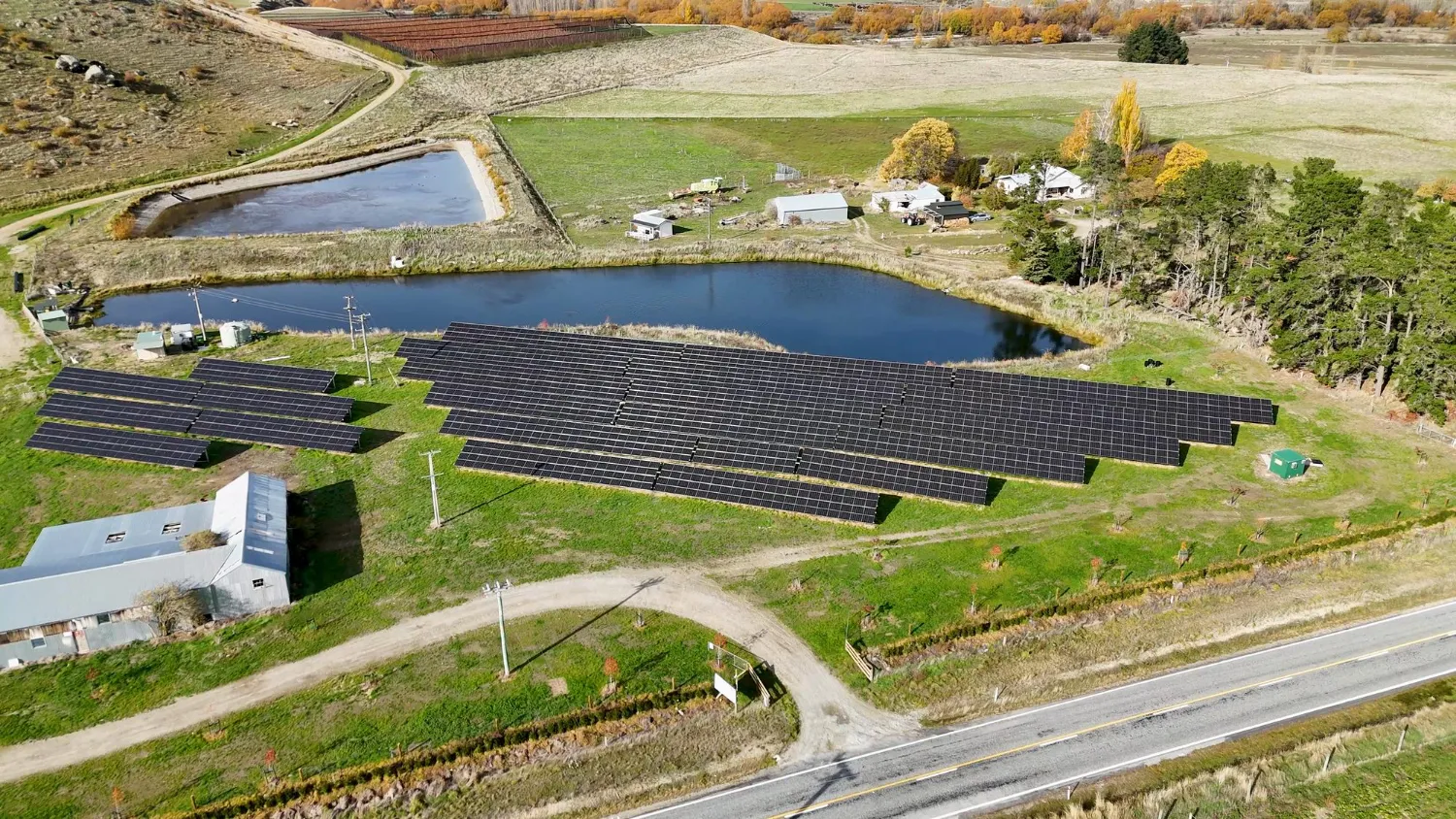 Aerial view of a ground-mounted solar array in open farmland