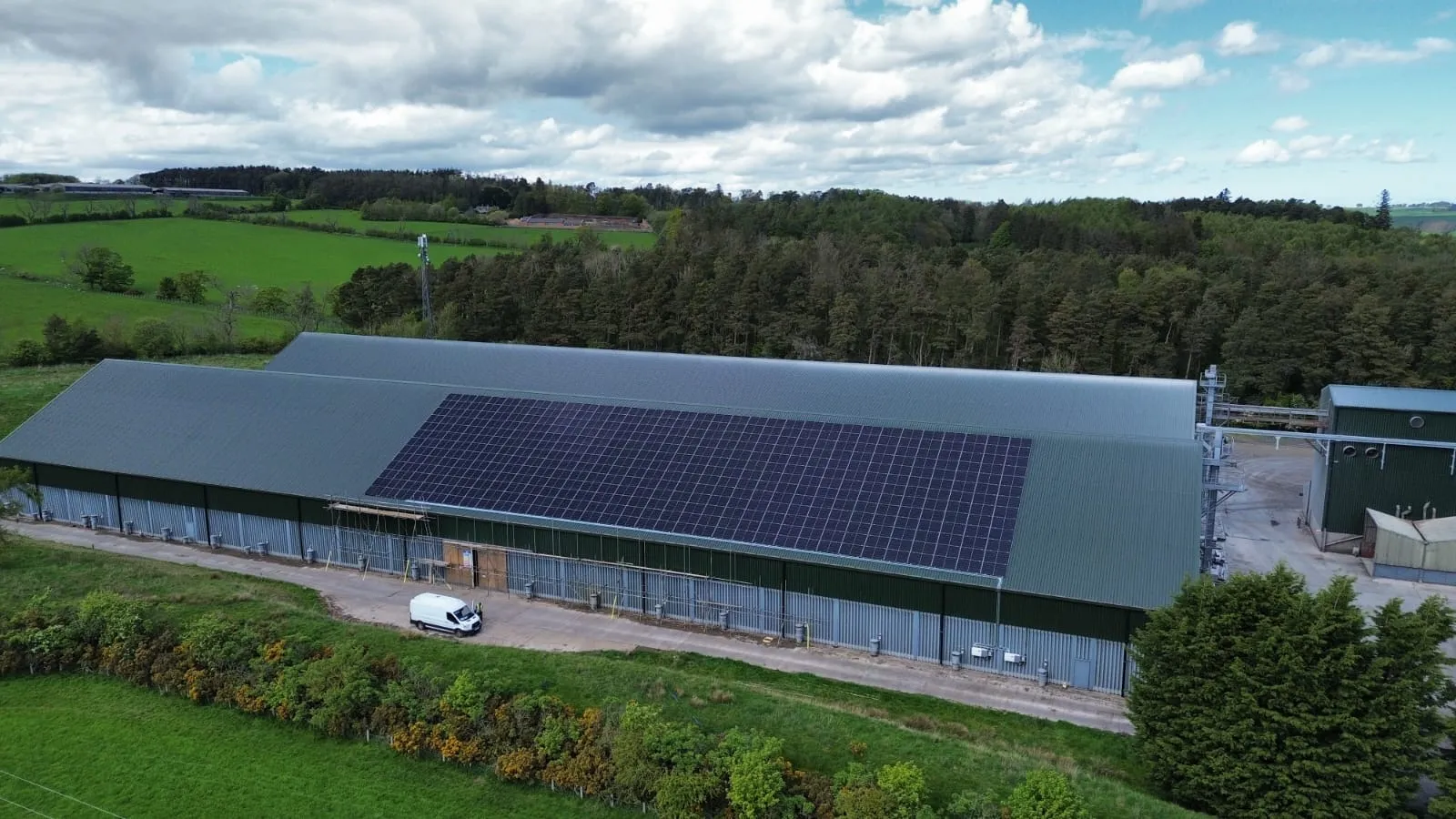 Drone view of a Green Team Partnership solar installation on a warehouse roof in open North East countryside