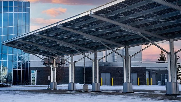 Solar carport canopy sheltering parking bays outside a commercial building