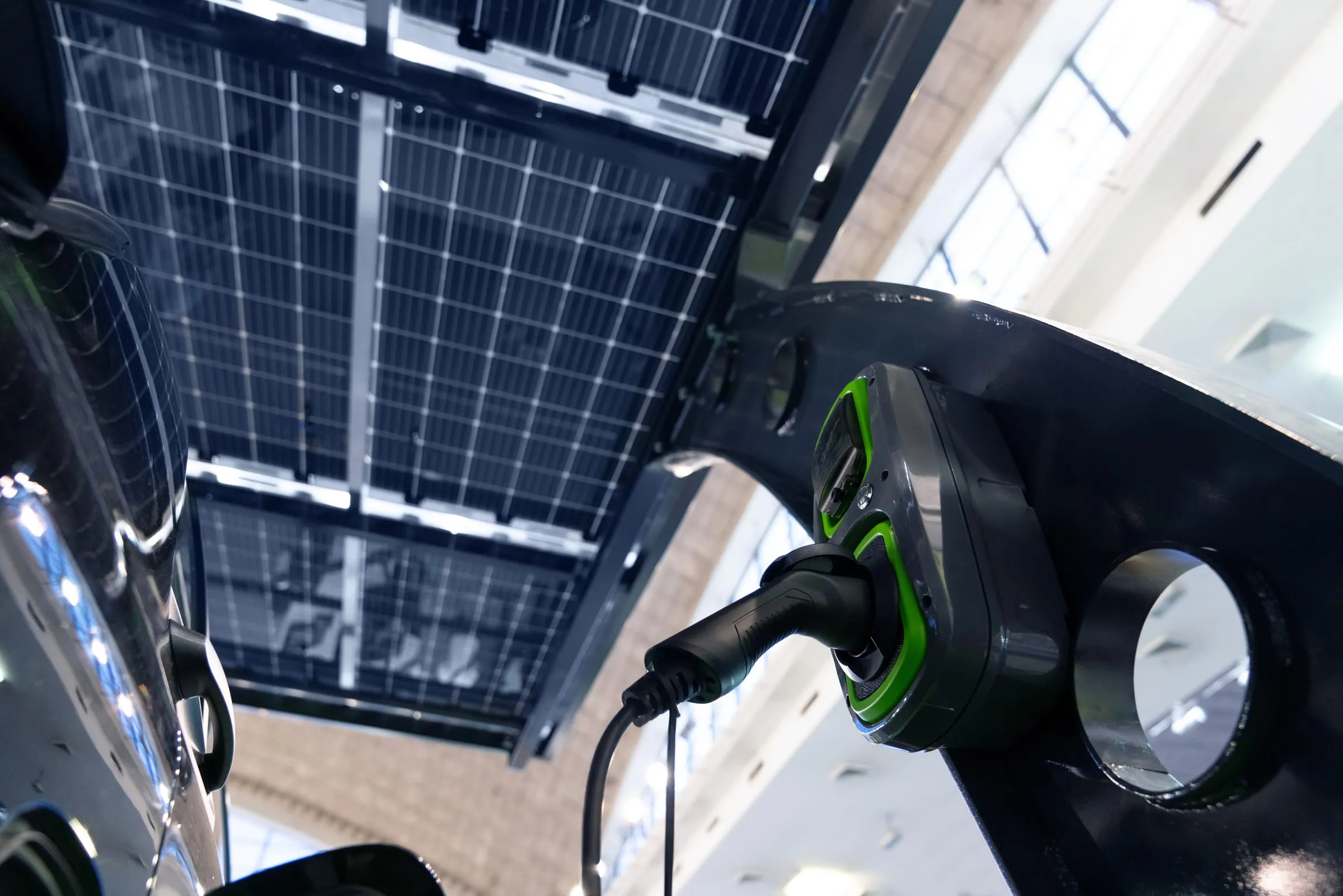 Electric vehicle charging beneath a solar panel carport canopy